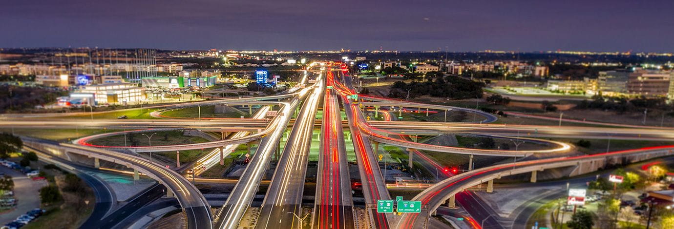 Aerial view of a busy well-lit highway at night.