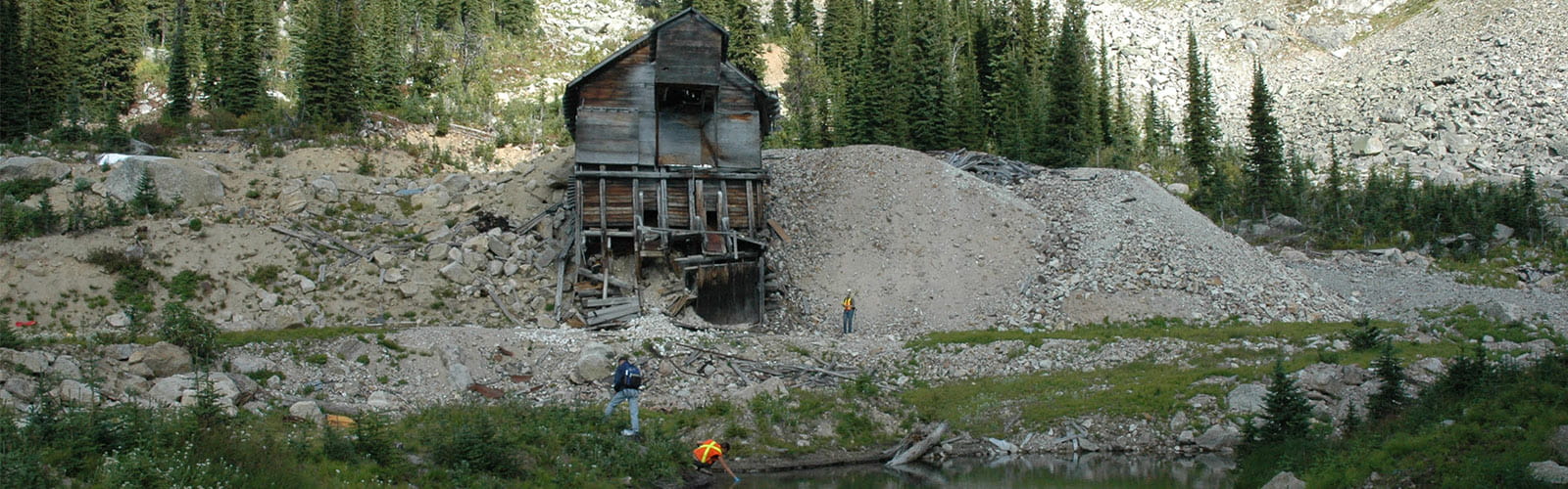 Abandoned mill building with waste rock and tailing piles